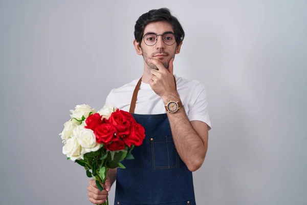 Молодой Латиноамериканец Держит Букет Белых Красных Роз Рукой Подбородке Думая — стоковое фото