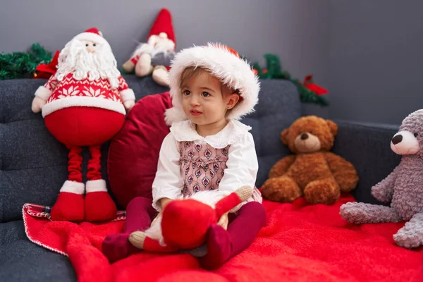 可爱的金发碧眼的小孩儿坐在沙发上玩着圣诞老人的装饰品 — 图库照片