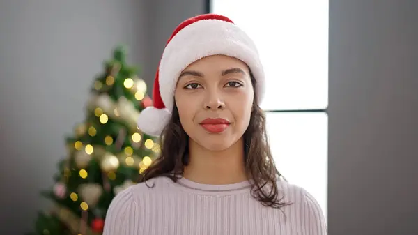 Νεαρή Όμορφη Ισπανόφωνη Γυναίκα Στέκεται Σοβαρή Δίπλα Στο Χριστουγεννιάτικο Δέντρο — Φωτογραφία Αρχείου