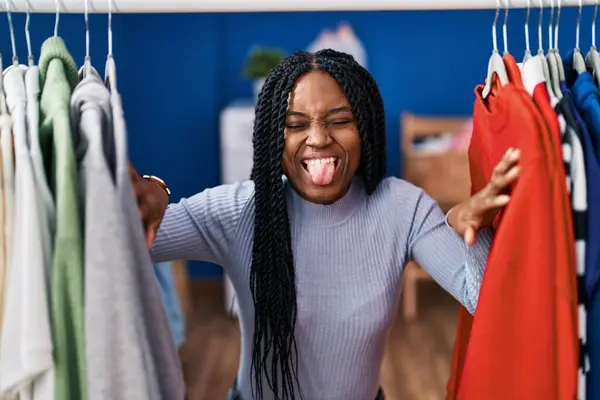 Африканская Американка Ищет Одежду Вешалке Торчащей Языком Довольная Смешным Выражением — стоковое фото