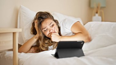 Genç ve güzel İspanyol kadın yatak odasında dokunmatik yastıkta korku filmi seyrediyor.