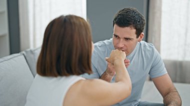 Güzel bir çift kanepede oturuyor ve birbirlerini el ele öpüşüyorlar.