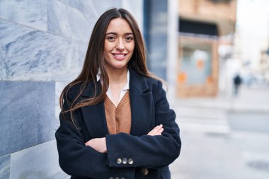 Sokakta kollarını kavuşturmuş genç, güzel İspanyol bir kadın.