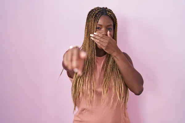 アフリカ系アメリカ人女性 ピンクの背景の上に立って笑い 口の上に手でカメラに指を指差し 恥の表現 — ストック写真