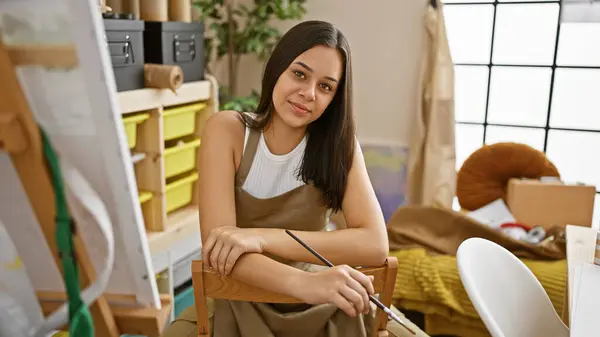 Jistá Usmívající Mladá Hispánská Umělkyně Sedí Svém Ateliéru Zkříženýma Rukama — Stock fotografie