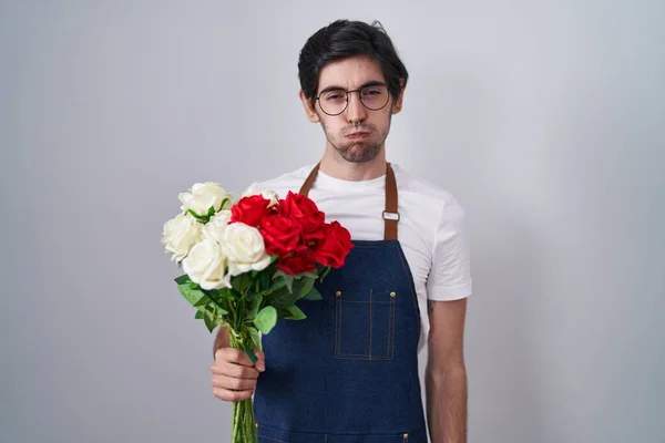 Joven Hombre Hispano Sosteniendo Ramo Rosas Blancas Rojas Hinchando Mejillas —  Fotos de Stock