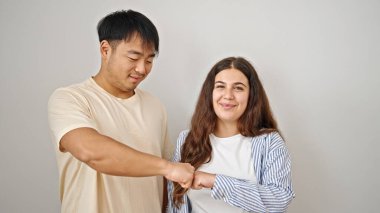 Kadın ve erkek, gülümseyen, kendinden emin, beyaz arka planda yumruk tokuşturan bir çift.