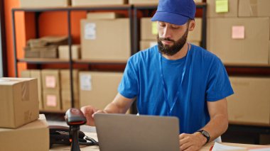 Ofisteki paketleri tarayan Latin kökenli genç ekommerce işçisi.