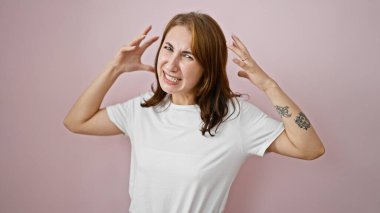 Genç bir kadın pembe arka planda yüksek sesle çığlık atıyor.