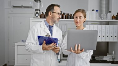 Laboratuvarın göbeğinde, iki bilimadamı, dizüstü bilgisayarın üzerinde derin bir sohbete dalmış, panodaki tıbbi bir belgeyi okumaya dalmışlardı.