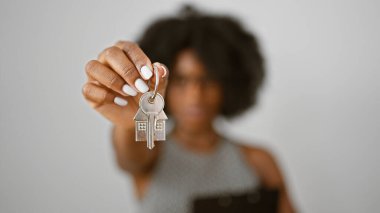 African american woman real state agent holding keys of new home over isolated white background clipart