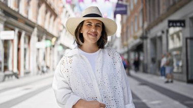 Stockholm sokaklarında kendinden emin gülümseyen genç, güzel İspanyol kadın.