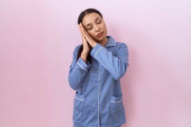 Mavi pijama giymiş genç bir Arap kadın uyuyordu. Yorgun düşler görüyordu ve elleri ile poz veriyordu. Gözleri kapalıyken gülümsüyordu.. 