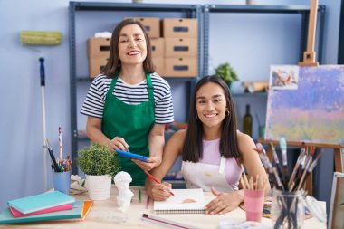 Two women artists using touchpad drawing on notebook at art studio