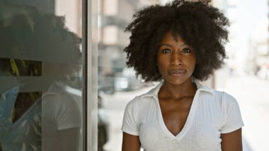 Sokakta ciddi bir ifadeyle duran Afrikalı Amerikalı kadın.