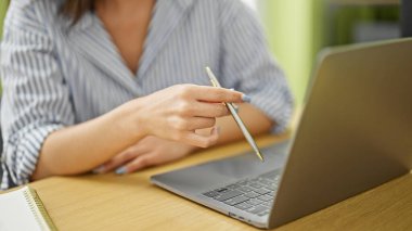 Genç beyaz kadın iş adamı ofiste dizüstü bilgisayar kullanıyor.