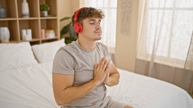 İçeride sakin bir sabah, çekici bir İspanyol erkeği dengeyi buluyor, pijamalarıyla yatakta dinleniyor, kulaklıkla müzik eşliğinde meditasyon yapıyor.