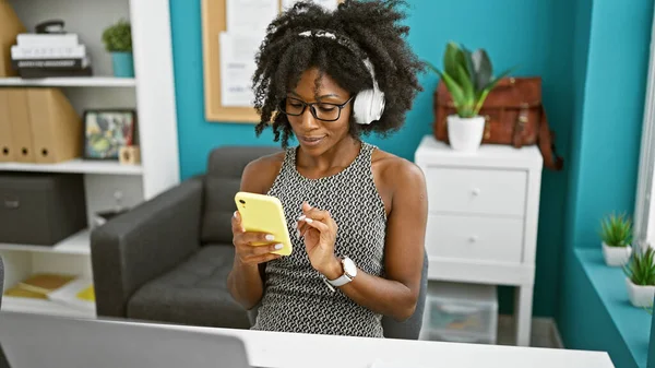 Trabajadora Negocios Afroamericana Usando Teléfonos Inteligentes Auriculares Oficina —  Fotos de Stock