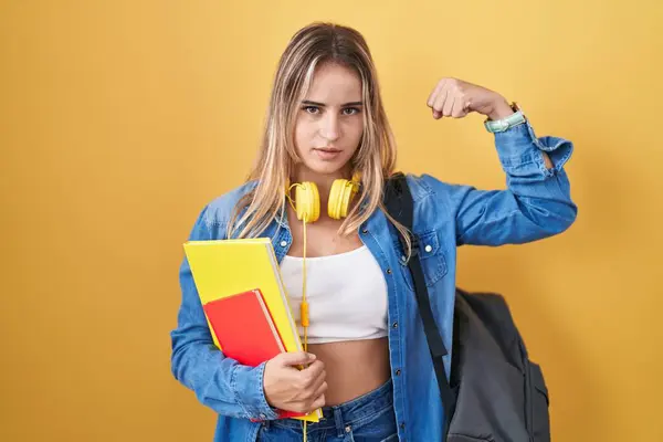 Young Blonde Woman Wearing Student Backpack Holding Books Strong Person — Stock Photo, Image