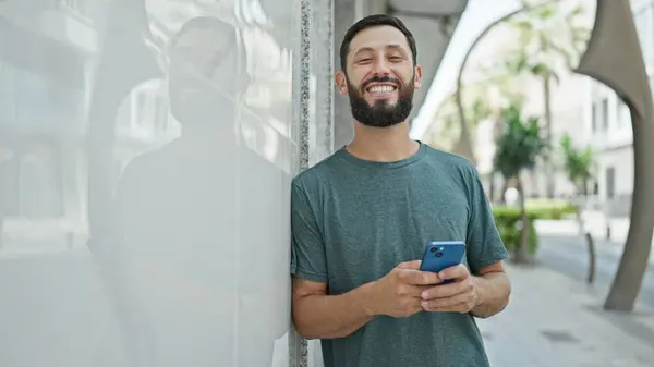 Молодий Іспаномовний Чоловік Використовує Смартфон Посміхаючись Вулиці — стокове фото