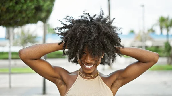 stock image African american woman smiling confident touching hair at street