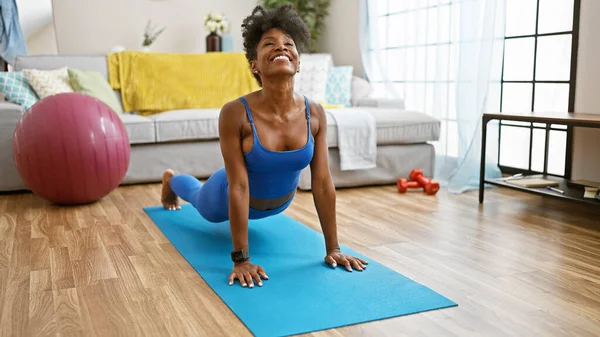African american woman stretching back training yoga at home