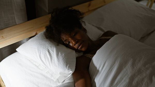 African american woman lying on bed sleeping at bedroom