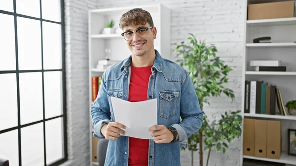 自信を持って若いヒスパニックの実業家は仕事で成功を楽しみ オフィスで文書を読んでいる間笑顔 — ストック写真