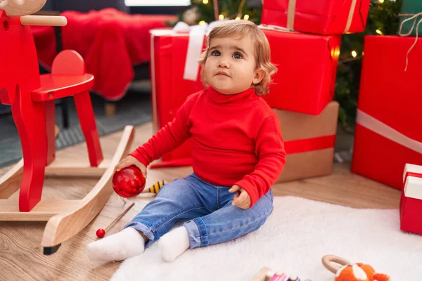 Αξιολάτρευτο Ισπανόφωνο Νήπιο Κρατώντας Χριστουγεννιάτικη Διακόσμηση Μπάλα Κάθεται Στο Πάτωμα — Φωτογραφία Αρχείου