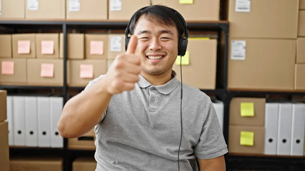 Eコマースビジネスワーカー オフィスで親指でジェスチャーをする音楽を聞く — ストック写真