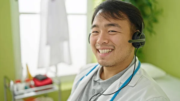 doctor smiling confident wearing headphones at clinic