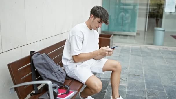 Mladý Hispánský Teenager Student Pomocí Smartphone Sedí Lavičce Univerzitě — Stock video