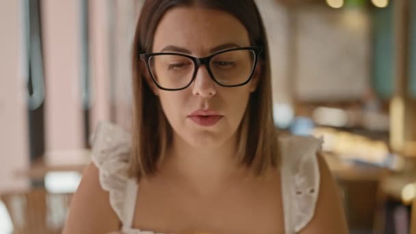화창한 그녀의 뜨거운 음료를 즐기는 히스패닉 안경을 식사에서 카페테리아 테이블에 — 비디오