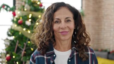 Orta yaşlı İspanyol kadın gülerek Noel 'i evde kutluyor.