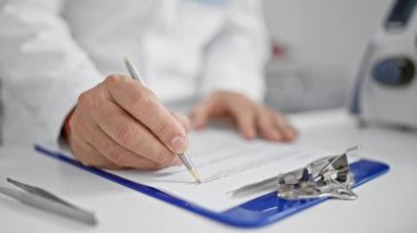 Titiz orta yaşlı bir adam, tıbbi araştırmasına dalmış gri saçlı bir bilim adamı, hızlı laboratuardaki panoya öfkeyle yazı yazıyor.