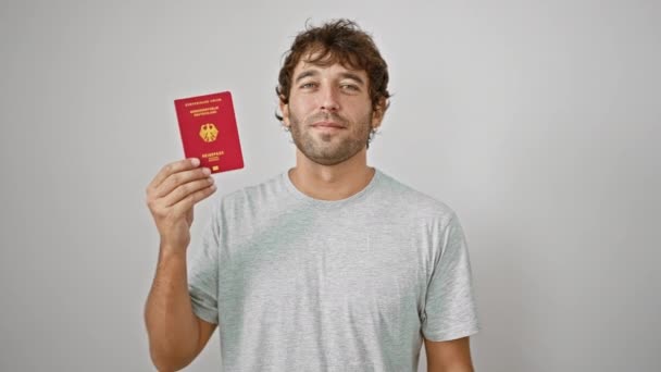 快乐的青年惊慌失措 满心喜悦地微笑着 漫不经心地拿着他的德国护照 带着白色的背景 准备渡假去欧洲旅行 — 图库视频影像