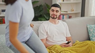 Birbirlerine aşık güzel bir çift, rahatça dinleniyor ve gülümsüyor TV 'de film izlerken, rahat evlerinin oturma odasındaki kanepede birlikte oturuyorlar.