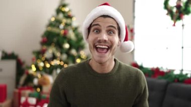 Genç İspanyol adam evde Noel ağacının yanında oturup öpüşürken görüntülü konuşma yapıyor.