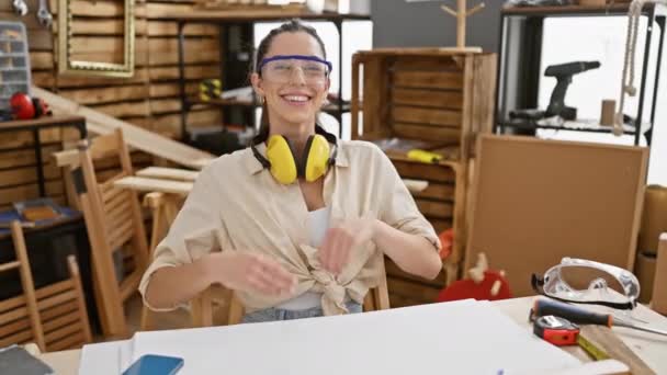 美丽的年轻惊慌失措的女人散发着对木工的信心 戴着安全眼镜 带着成功和积极向上的微笑 — 图库视频影像