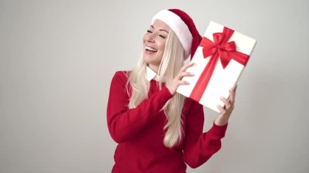 Jovem Loira Vestindo Chapéu Natal Ouvindo Som Presente Sobre Fundo — Vídeo de Stock