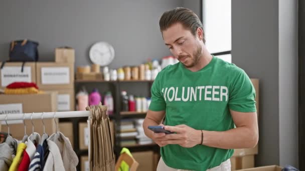 Jovem Hispânico Homem Voluntário Sorrindo Confiante Usando Smartphone Centro Caridade — Vídeo de Stock