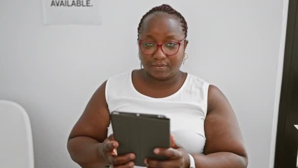 African American Γυναίκα Χρησιμοποιώντας Touchpad Κάθεται Στην Καρέκλα Στην Αίθουσα — Αρχείο Βίντεο