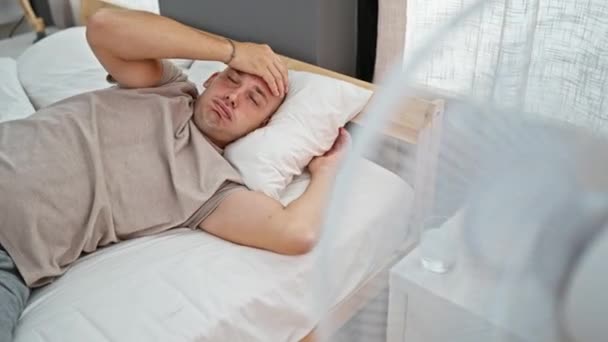 年轻的惊慌失措的男人躺在床上汗流浃背 在卧室里用呼吸器 — 图库视频影像