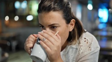 Kafeteryada oturup kahve içen güzel, genç bir İspanyol kadın.