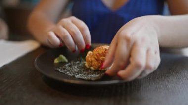 Muhteşem İspanyol kadın nefis uni suşinin tadını çıkarıyor. Şık restoranda Japon deniz ürünleri ziyafeti veriyor.