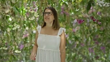 Gözlüklü mutlu İspanyol kadın, renkli, modern bir müzede fütürist bitki sergisi araştırması.