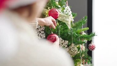 Evde Noel ağacı süsleyen olgun İspanyol kadın.