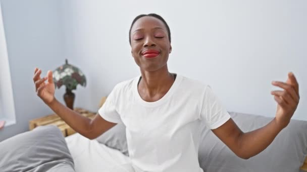 自信に満ちた幸せなアフリカ系アメリカ人女性は 寝室のベッドに横たわって指で自分を指差しています 誇り高く女性は素晴らしく リラックスして元気な屋内 — ストック動画