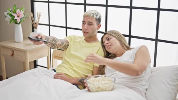 美丽的夫妻在卧室里看电视争夺遥控装置 — 图库视频影像