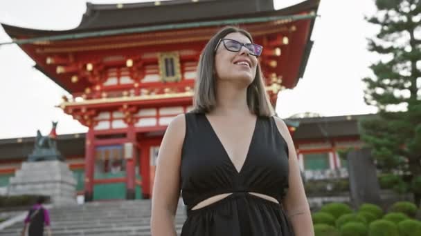 メガネをかけた美しいヒスパニック系女性 明らかに京都の素晴らしい寺院の周囲に魅了された笑顔でポーズ — ストック動画